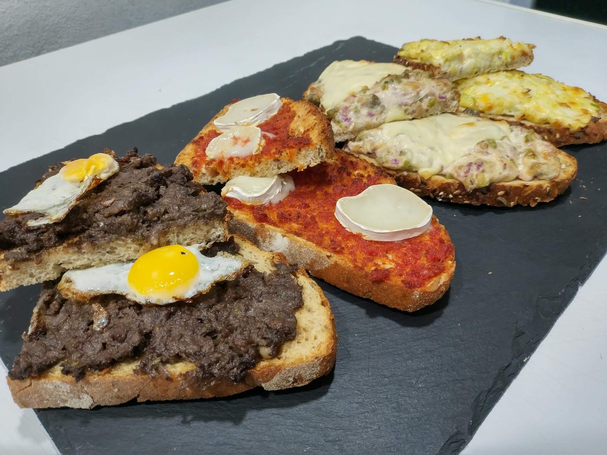 varias tostas típicas sobre tabla de pizarra